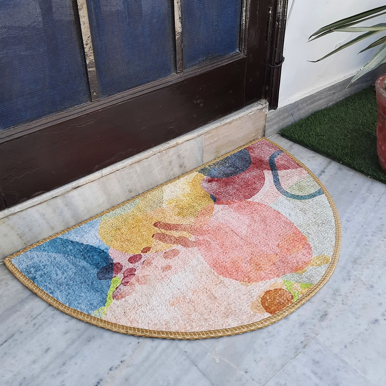 Colorful semi-round geometric rug placed at a stylish home doorway.