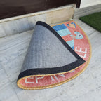 Decorative half-circle floor mat featuring a vibrant geometric design at the entrance.